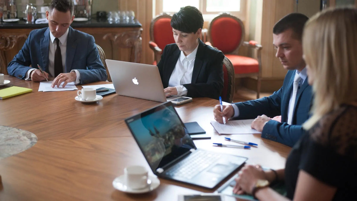 Uczestnicy spotkania biznesowego pracujący przy wspólnym stole